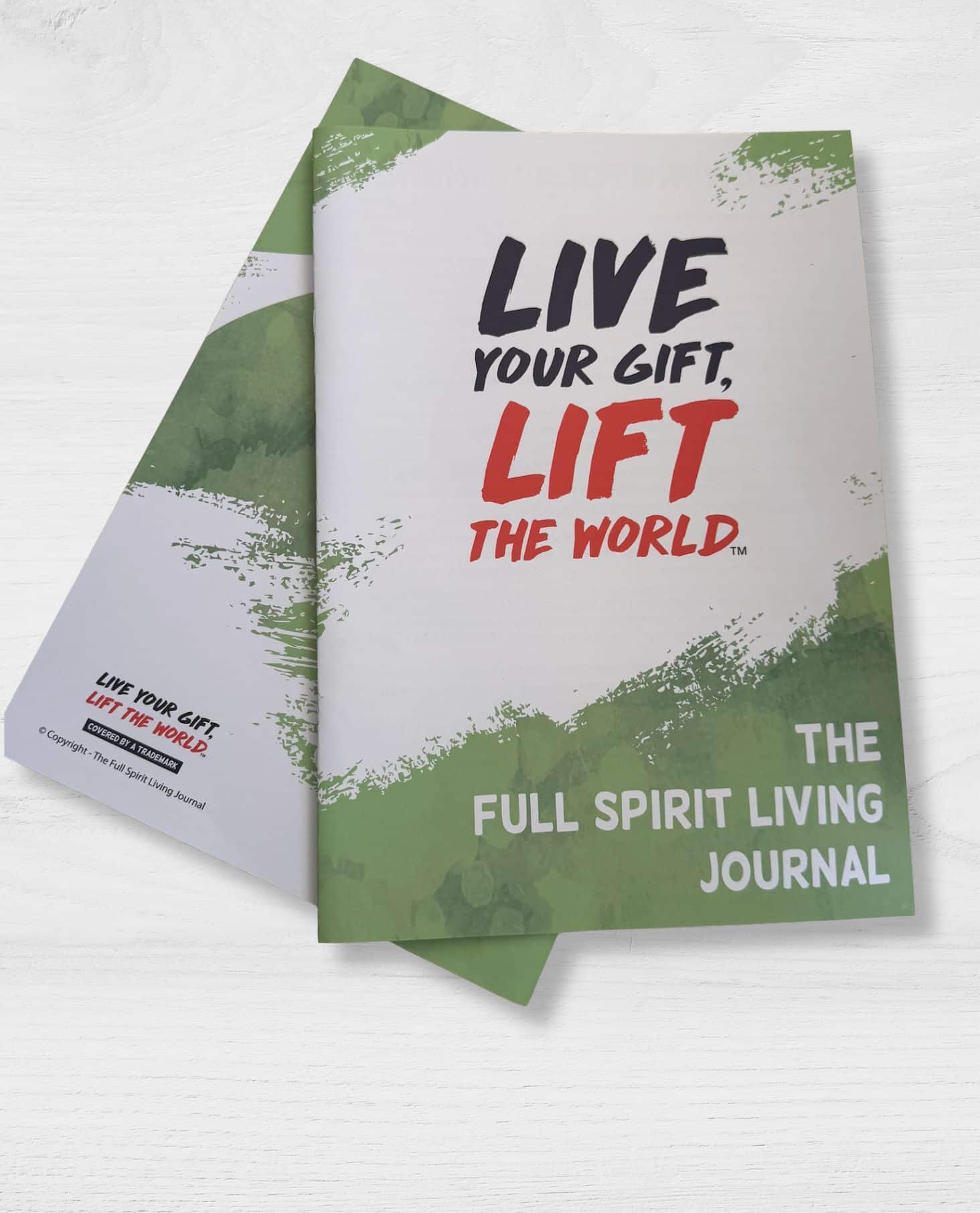 Two copies of the Full Spirit Living Journal showing the cover with the text Live Your Gift, Lift The World and green brushstroke design
