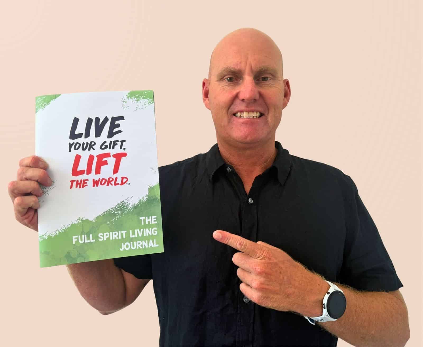 Troy Devine Smiling With His 10-Day Energy Reset Workbook